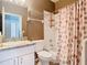 Bathroom featuring granite vanity, decorative mirror, and seashell patterned shower curtain at 1525 Oakwood Ct, Apopka, FL 32703