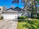 Charming home with manicured lawn, two-car garage, and welcoming front entrance at 1525 Oakwood Ct, Apopka, FL 32703