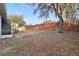 Backyard featuring a brick wall with mature trees and natural ground cover at 1601 Stoneywood Way, Apopka, FL 32712