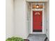 Close-up of a vibrant red front door with decorative glass and modern hardware, offering a welcoming entrance at 1601 Stoneywood Way, Apopka, FL 32712