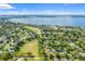 Aerial view of neighborhood with homes, mature trees and a large lake on the horizon at 1670 Blue Lagoon Cir, Mascotte, FL 34753