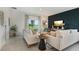 Cozy living room with modern decor, featuring comfortable seating, a dark accent wall, and sliding glass doors at 1670 Blue Lagoon Cir, Mascotte, FL 34753