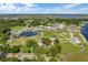 Wide aerial shot showcases a well-maintained community center featuring a pond, green spaces and modern architecture at 1676 Blue Lagoon Cir, Mascotte, FL 34753