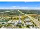 Aerial view of a highway, cell tower, lakes, and commercial buildings set against a clear, blue sky backdrop at 1676 Blue Lagoon Cir, Mascotte, FL 34753