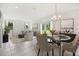 Sunlit dining area with glass table, chandelier, and view of the backyard at 1676 Blue Lagoon Cir, Mascotte, FL 34753