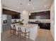 Modern kitchen featuring dark cabinetry, stainless steel appliances, and a granite island with bar stool seating at 1676 Blue Lagoon Cir, Mascotte, FL 34753