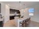 Modern kitchen with stainless steel appliances, a center island, and dark wood cabinetry set against light countertops at 1676 Blue Lagoon Cir, Mascotte, FL 34753