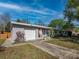 Charming home exterior with attached garage, well-manicured lawn, and vibrant landscaping at 1700 Edmundshire Rd, Orlando, FL 32812