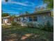 Lawn view of a charming home with blue shutters and vibrant landscaping at 1700 Edmundshire Rd, Orlando, FL 32812