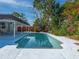 Backyard with a refreshing in-ground swimming pool surrounded by a white concrete deck at 1700 Edmundshire Rd, Orlando, FL 32812