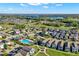 Aerial view of residential neighborhood with a community pool, a lake in the distance, and solar panels on some of the homes at 1740 Standing Rock Cir, Oakland, FL 34787