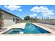 A backyard with a pool and spa featuring brick pavers and clear blue water surrounded by a white fence at 1740 Standing Rock Cir, Oakland, FL 34787