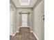 Inviting hallway with archways, wood-look tile flooring, a skylight, and neutral paint at 1740 Standing Rock Cir, Oakland, FL 34787