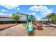 Community playground featuring a slide and climbing structures in a fenced area with mulch ground cover at 1740 Standing Rock Cir, Oakland, FL 34787