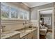 Bathroom featuring marble counters and sink with wainscoting and view into bedroom at 1800 Wycliff Dr, Orlando, FL 32803