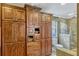 Bathroom showcasing custom wooden cabinetry providing ample storage and a tiled shower with glass door at 1800 Wycliff Dr, Orlando, FL 32803