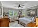 Sunlit bedroom featuring a ceiling fan, a sitting area, area rug and views of the landscape at 1800 Wycliff Dr, Orlando, FL 32803