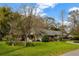 Charming single-story home with a well-manicured front lawn and mature trees on a sunny day at 1800 Wycliff Dr, Orlando, FL 32803