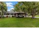 Backyard features a screened-in porch, an outdoor pergola with car, and well-maintained lawn at 1800 Wycliff Dr, Orlando, FL 32803