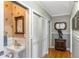 Hallway featuring storage closet, wood floors, and view to bathroom with palm wallpaper at 1800 Wycliff Dr, Orlando, FL 32803