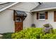 Side entrance of the home features a rustic wooden door, shutters, and lush greenery at 1800 Wycliff Dr, Orlando, FL 32803