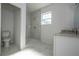 Modern bathroom with tiled walk-in shower, granite vanity, and tiled floor at 1857 Manitoba Ct, Poinciana, FL 34759