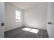 Bright bedroom with neutral gray carpet and white walls illuminated by a window at 1857 Manitoba Ct, Poinciana, FL 34759