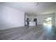 Bright, open living room showcasing sleek wood-look floors and open kitchen space at 1857 Manitoba Ct, Poinciana, FL 34759