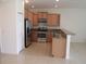 Open concept kitchen with stainless steel appliances, granite countertops, and light wood cabinets at 1973 Portofino Meadows Blvd, Orlando, FL 32824