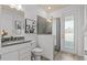 This bright bathroom features a glass shower door, gray hexagon tiles, and a gray countertop at 2135 Weatherly Way, Orlando, FL 32820