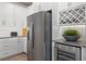 Modern kitchen with stainless steel refrigerator, wine cooler, and sleek white cabinetry at 2135 Weatherly Way, Orlando, FL 32820