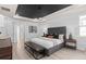 This is a main bedroom featuring a decorative tray ceiling, sitting area, and wood-style tile floors at 2135 Weatherly Way, Orlando, FL 32820