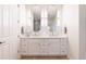 Bright bathroom showcasing a double sink vanity with decorative mirrors, and white cabinets and drawers at 2161 Snow Rd, Orlando, FL 32814