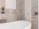 This bathroom close-up features a soaking tub with a waterfall faucet and marble tiling at 2161 Snow Rd, Orlando, FL 32814