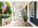 Welcoming front porch with white columns and railings, featuring a swing, and lush greenery at 2161 Snow Rd, Orlando, FL 32814