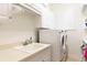 The laundry room features a utility sink, white cabinets, and front loading washer and dryer at 2161 Snow Rd, Orlando, FL 32814