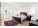 This main bedroom boasts a tray ceiling, wood floors, and large windows letting in natural light at 2161 Snow Rd, Orlando, FL 32814