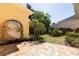 Charming outdoor patio area with decorative brickwork, lush landscaping, and a unique mural feature at 2161 Snow Rd, Orlando, FL 32814