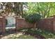 Well-kept yard with a brick wall, iron gate, and established landscaping at 2161 Snow Rd, Orlando, FL 32814