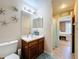 Bathroom with decorative starfish, a wooden vanity, and a view into an adjacent bedroom at 2253 Lake Pointe Cir, Leesburg, FL 34748