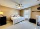 Bedroom featuring a large window, ceiling fan, neutral tones, and plush carpeting at 2253 Lake Pointe Cir, Leesburg, FL 34748