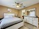 Comfortable bedroom featuring a ceiling fan, light-colored walls, and ample natural light from large windows at 2253 Lake Pointe Cir, Leesburg, FL 34748