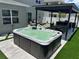 Backyard hot tub area with outdoor kitchen and outdoor dining featuring artificial turf at 2403 Biscotto Cir, Davenport, FL 33897