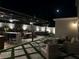 Night view of an outdoor living space with a bar, hot tub, and ample seating under a modern pergola at 2403 Biscotto Cir, Davenport, FL 33897