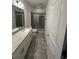 Well-lit bathroom featuring a granite countertop, tiled floor, and glass shower at 2403 Biscotto Cir, Davenport, FL 33897