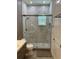 Modern bathroom with a glass-enclosed shower and elegant marble tiling at 2403 Biscotto Cir, Davenport, FL 33897