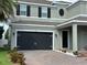 A black garage door enhances the exterior of this light gray home with well manicured landscaping at 2403 Biscotto Cir, Davenport, FL 33897