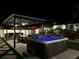 Backyard hot tub beneath a pergola, complete with a kitchen, dining, and a beautifully landscaped yard at 2403 Biscotto Cir, Davenport, FL 33897