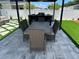 Backyard dining area with a table, seating for six, and a custom stone patio with artificial turf accents at 2403 Biscotto Cir, Davenport, FL 33897