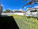 Lush backyard view, featuring well-maintained lawn and mature trees, enclosed by a clean white fence at 2707 Barnsley Ln, Kissimmee, FL 34744